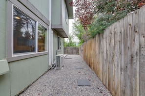 A narrow outdoor pathway with a wooden fence on one side and a building on the other. - Modern Boise Townhome Minutes From Boise Airport! (Boise)