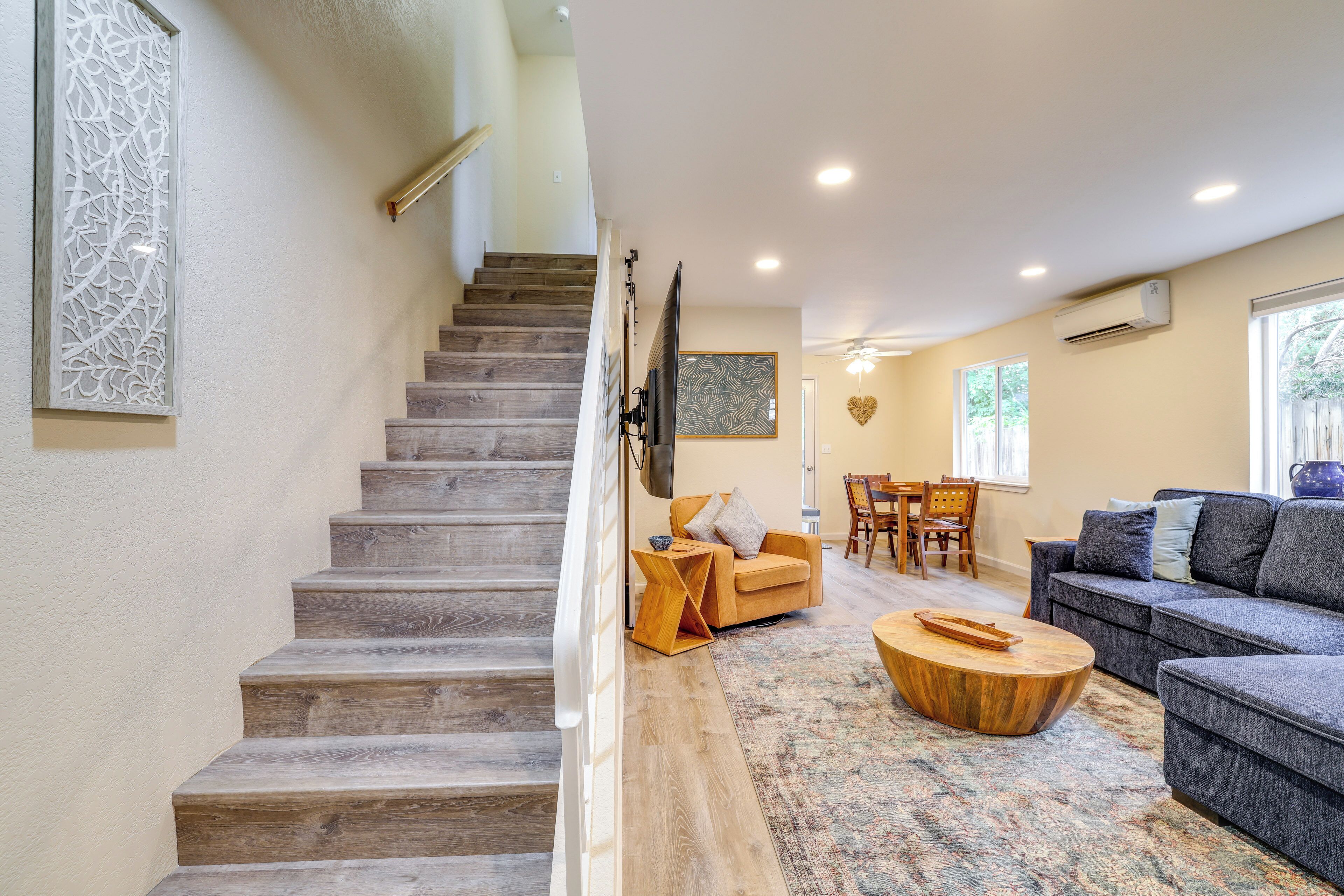 A staircase leading to a living area with a sofa, a coffee table, and a dining table.