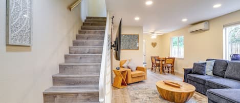 A staircase leading to a living area with a sofa, a coffee table, and a dining table.