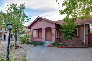 A residential building with a red facade, a front porch, and a clear sky. - Walk to Downtown Roswell! Quaint Home w/ Patios (Roswell)