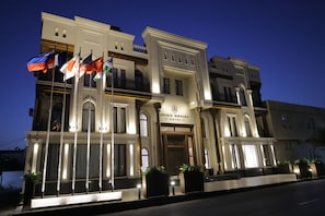 A hotel with a classic facade, multiple flags, and a prominent entrance. - Unique Hotel Bukhara (Bukhara)