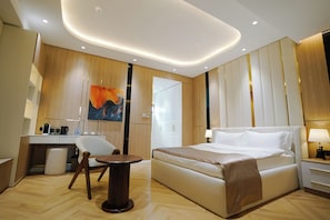 A modern hotel room with a large bed, a desk, and a chair. - Unique Hotel Bukhara (Bukhara)