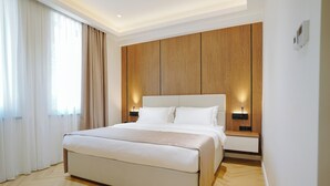 Un dormitorio moderno con una cama grande, paneles de madera y lámparas de noche.