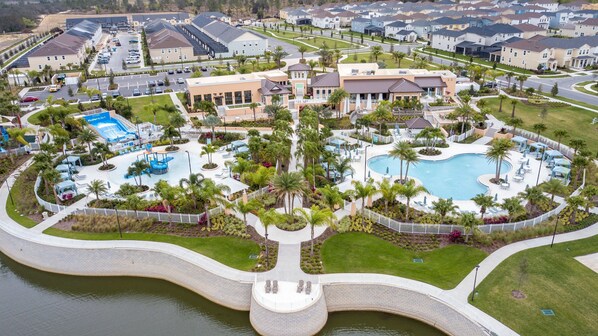 An aerial view of a residential area with a swimming pool, lounge chairs, and a children's play area. - Brand New 6BR Villa Pool Spa PS5 Loft 2380 (Kissimmee)