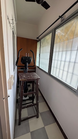 A narrow corridor with a wooden bench, a ceiling fan, and a window with a view.