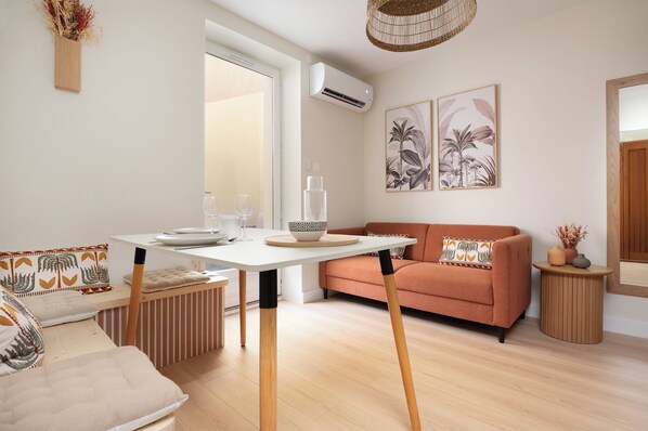 A modern living room with a sofa, a dining table, and a small side table. - Apartment with a private courtyard • Cathedral, 15 minutes away • Air Conditioning • Free parking (Albi)