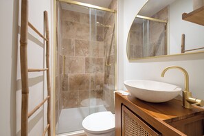 A modern bathroom with a glass shower enclosure, a wooden vanity with a vessel sink, and a toilet. - Apartment with a private courtyard • Cathedral, 15 minutes away • Air Conditioning • Free parking (Albi)