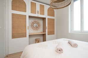 A bedroom with a bed, a hanging light, and a wall-mounted decorative piece. - Apartment with a private courtyard • Cathedral, 15 minutes away • Air Conditioning • Free parking (Albi)
