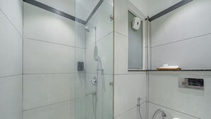 Un baño moderno con ducha de vidrio, inodoro y secador de manos.
