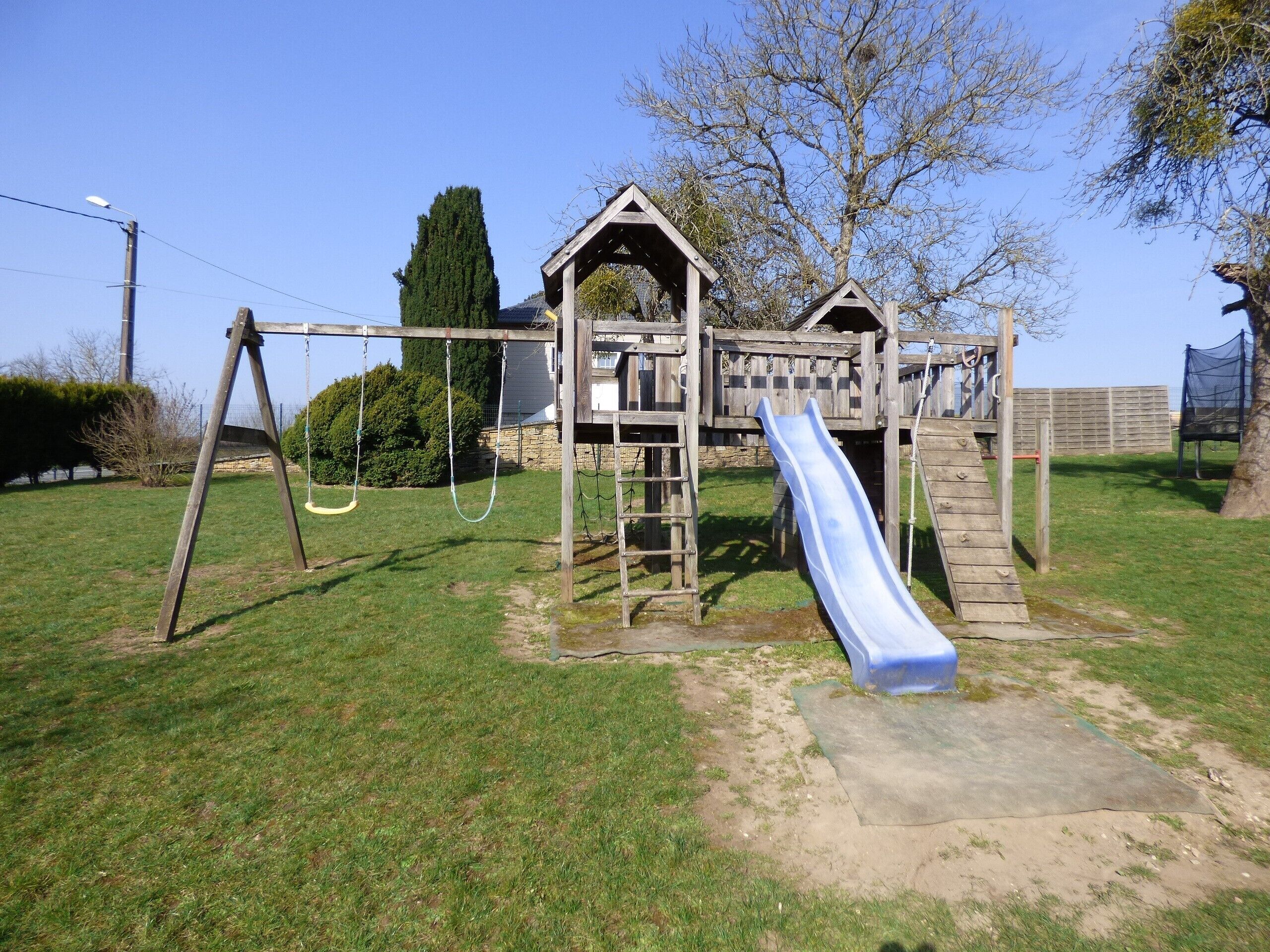 A playground with a slide, swings, and a climbing structure.