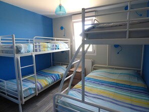 Habitación con literas, ventana y radiador.