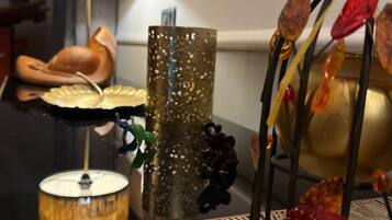 Et bord med en lampe, pynteting og en vase med blomster.