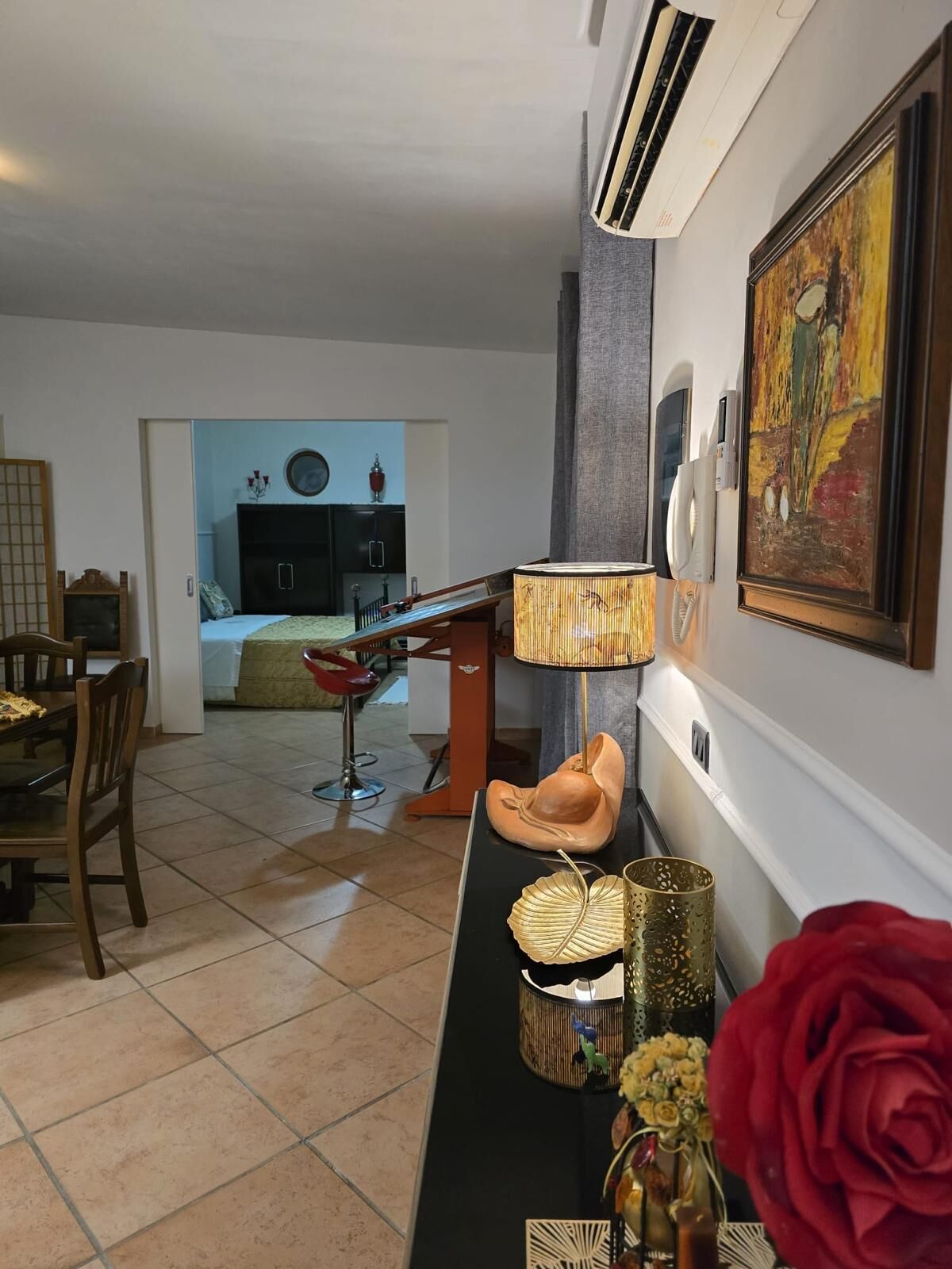 Ein Wohnzimmer mit Essbereich, einer Küche im Hintergrund und einem Bild an der Wand.