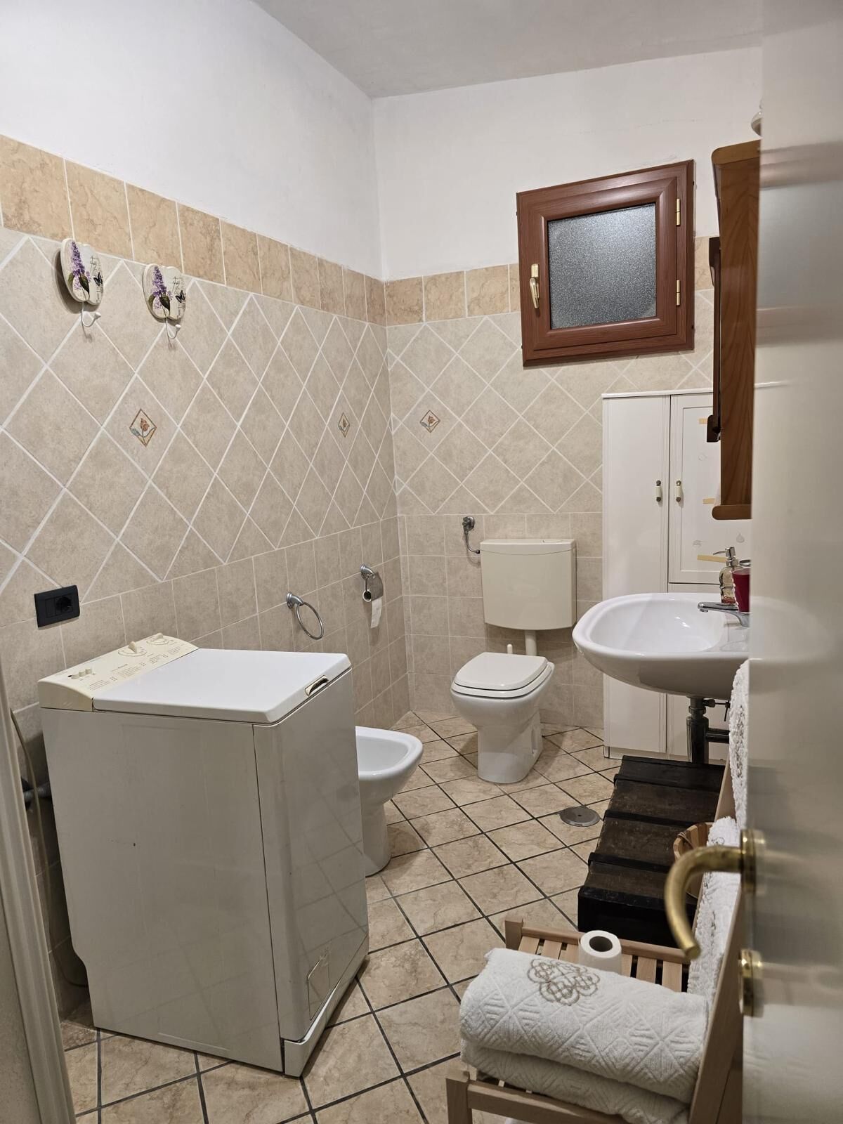 A bathroom with a toilet, sink, and shower area.