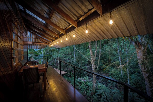 An interior space with a wooden deck overlooking a forested area.