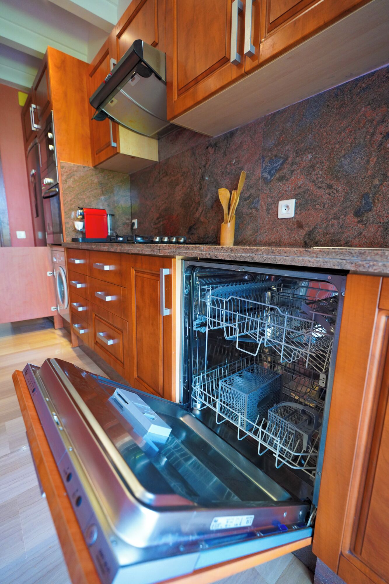 Eine Küche mit Holzschränken, einem eingebauten Backofen und einem Geschirrspüler.