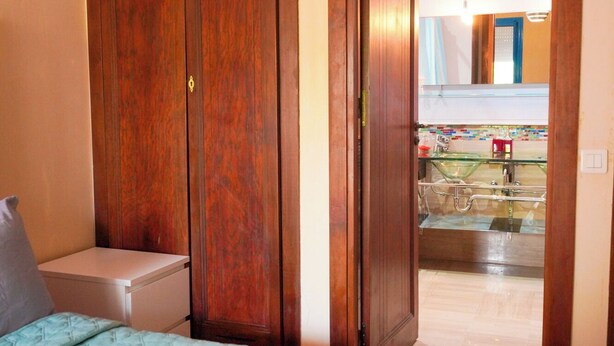 A hotel room with a bed, a bedside table, a wardrobe, and a bathroom visible through an open door. - Green Haven in Skhirat, Pool & Walk to the Beach (Skhirat)