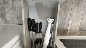Casa de banho com design moderno, apresentando zona de duche com porta de vidro, uma toalha branca e uma toalha preta e branca penduradas na parede.
