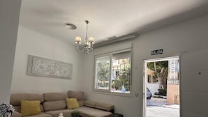 Uma sala de estar moderna com sofá, mesa de centro e lustre.