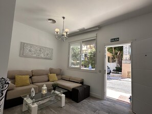 Een moderne woonkamer met een bank, een salontafel en een kroonluchter.