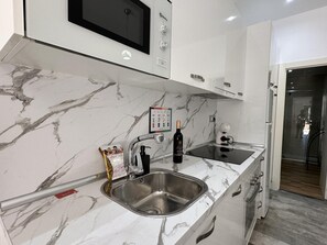 A modern kitchen with a marble countertop, stainless steel sink, and a built-in oven. - 2-Bedroom Apartment with Parking, 100 m from La Carihuela Beach (Torremolinos)