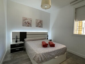 A modern bedroom with a bed, bedside tables, a lamp, and two wall-mounted paintings. - 2-Bedroom Apartment with Parking, 100 m from La Carihuela Beach (Torremolinos)