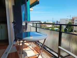 Een balkon met een ronde tafel en uitzicht op de skyline.