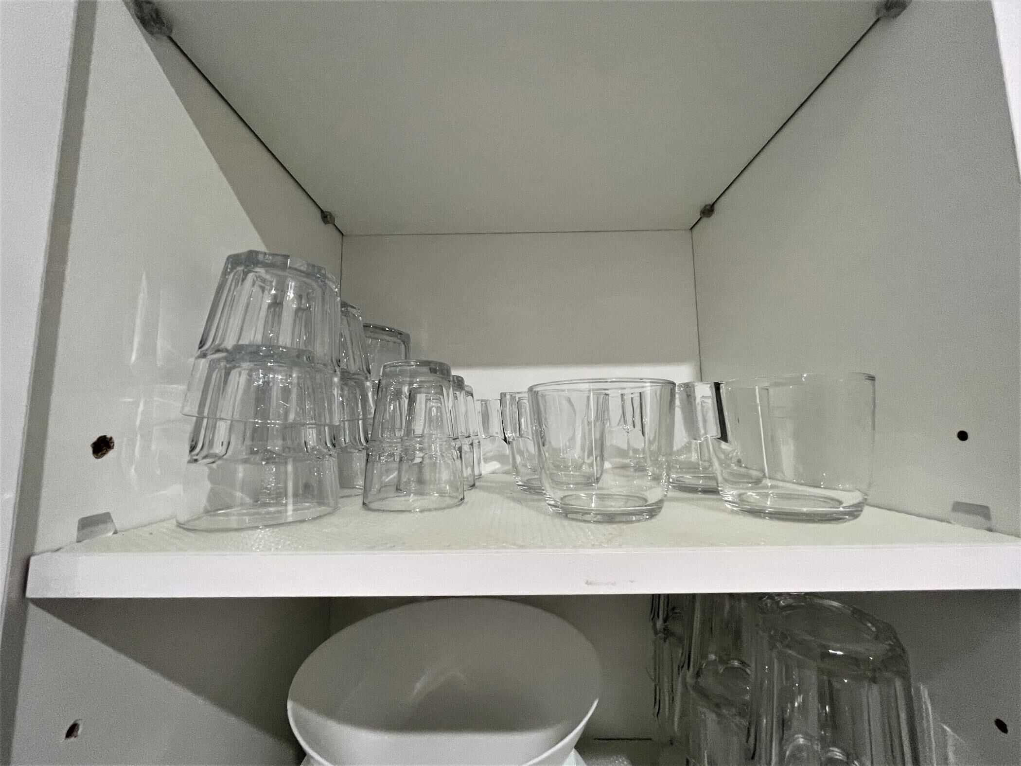 Une étagère contenant divers objets en verre transparent.