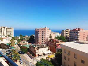 A coastal cityscape with high-rise buildings, a clear blue sky, and a view of the sea. - Renovated Studio with Sea-View Terrace and Pool in Central Torremolinos (Torremolinos)