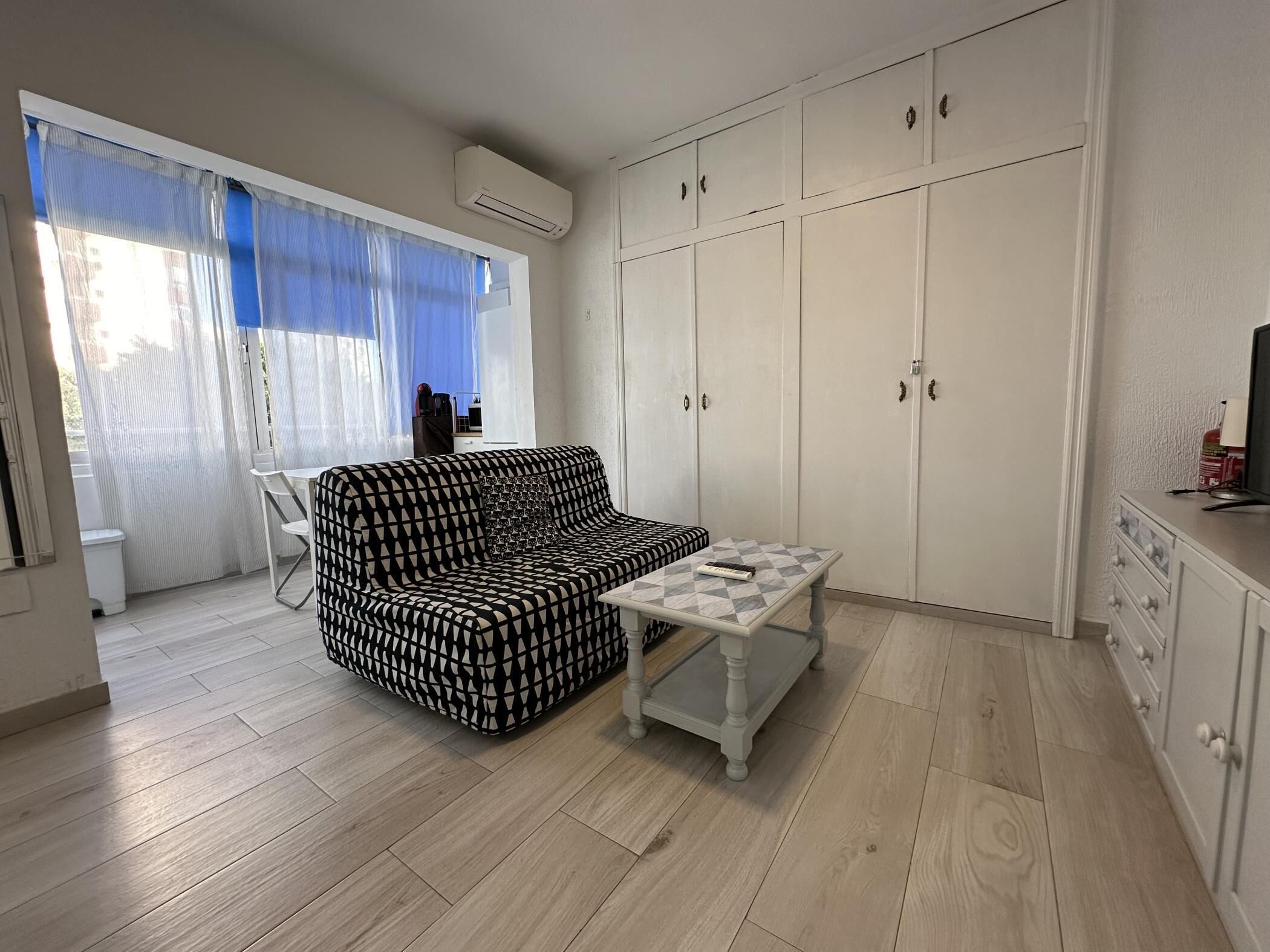 Un petit salon comprenant un canapé, une table basse et une armoire.