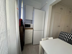A compact kitchen with a microwave, refrigerator, and a small table. - One-Bedroom Apartment by Torremolinos Centre with WiFi and A/C (Torremolinos)