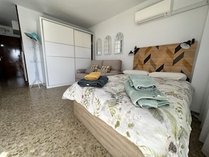 A bedroom with a bed, a wardrobe, a door, and a wall-mounted air conditioner. - Studio with Sea-View Terrace, Pool and WiFi in Central Torremolinos (Torremolinos)