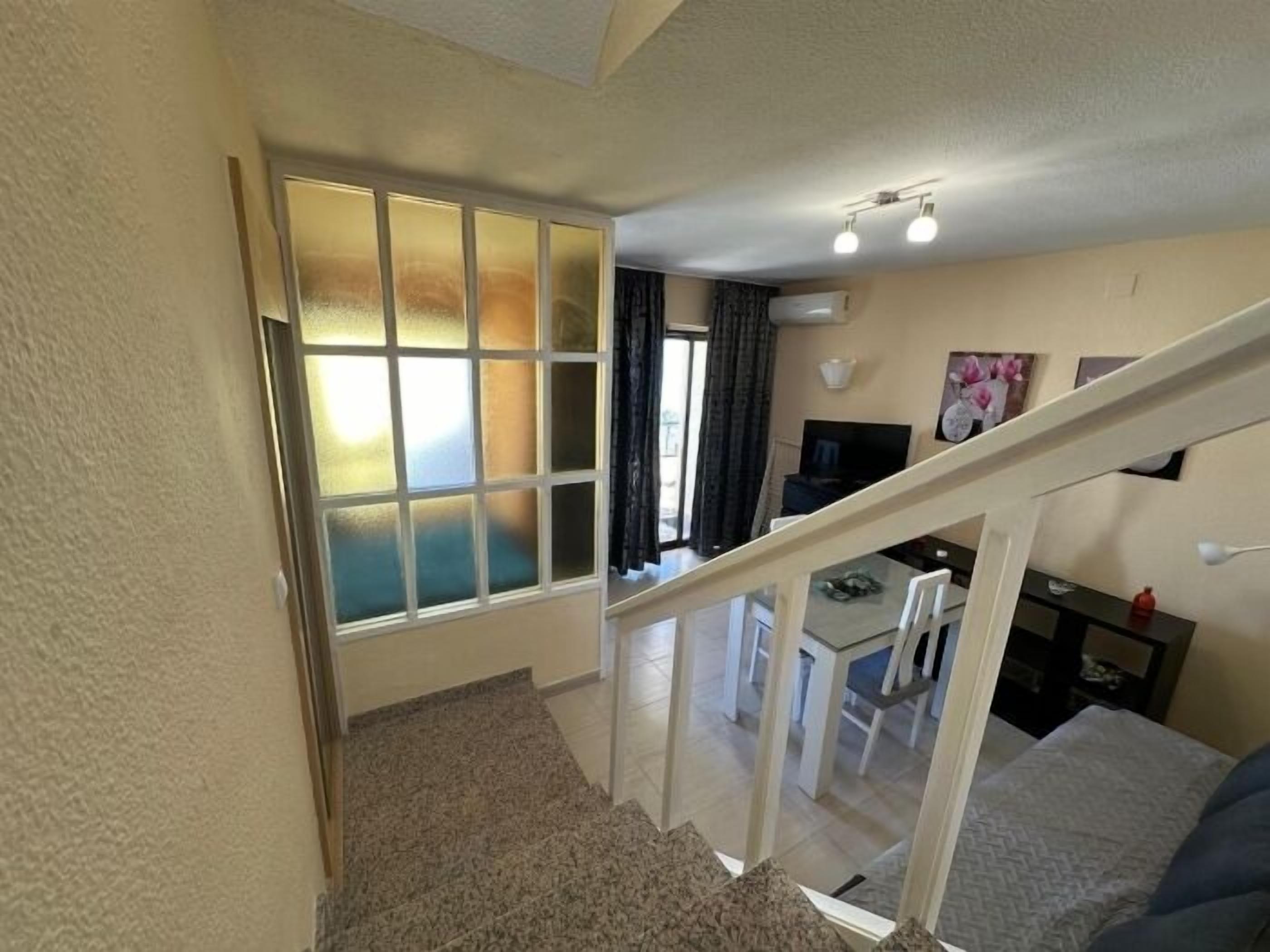 A staircase leading to a dining area with a view of the outdoors.