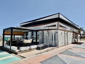 Edifici modern amb zona d'estar coberta a l'exterior i piscina.