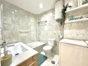 Een badkamer met een bad, toilet en wastafel.