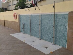 A tiled wall with a poolside area, including a lifebuoy and a metal railing. - Sea-View Studio with Pool, 100 m from the Centre of Torremolinos (Torremolinos)