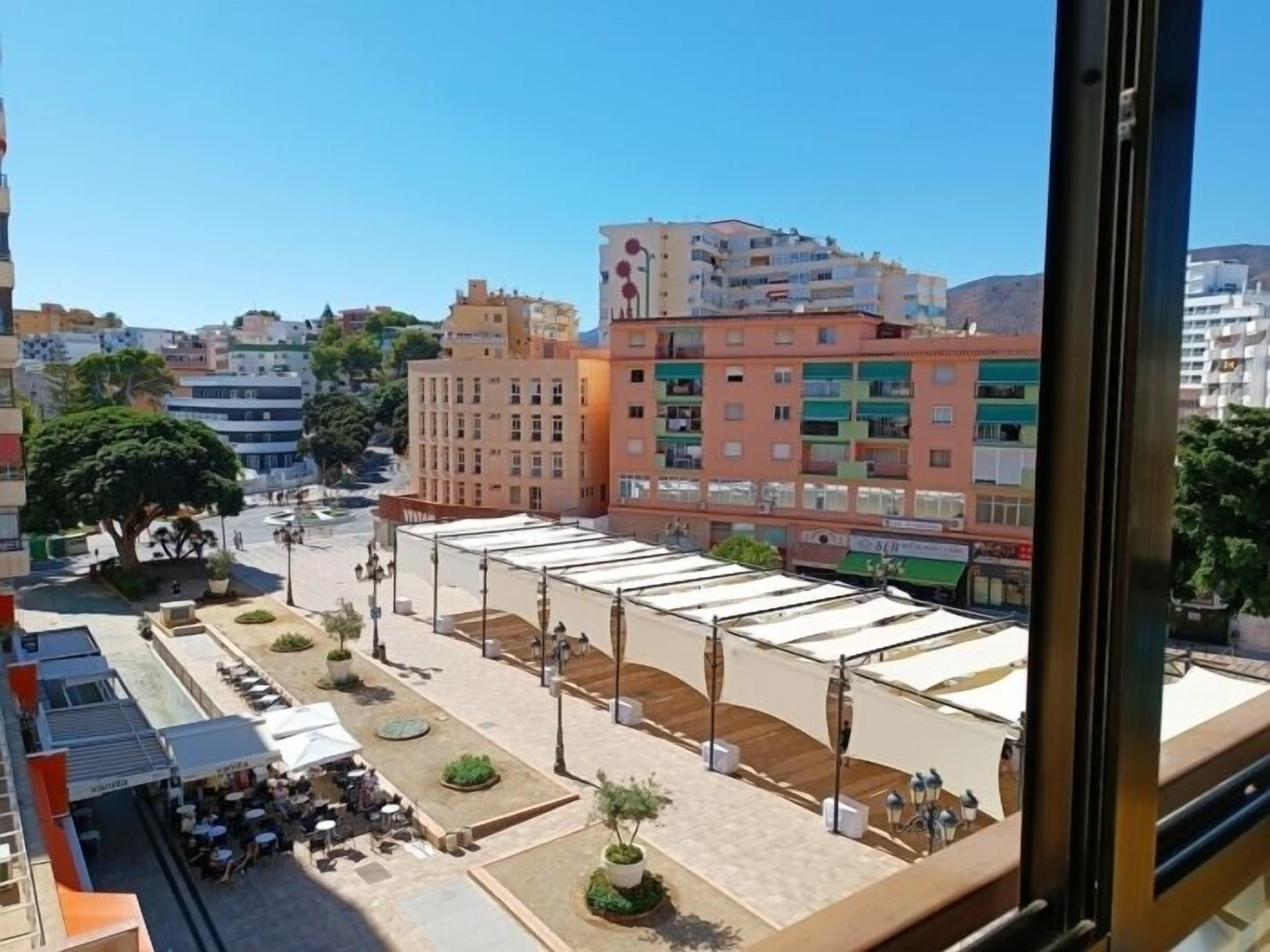 A hotel courtyard with outdoor seating and a view of the cityscape.