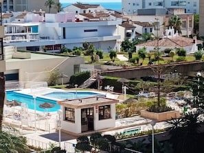 Een hotel met een zwembad, terras en uitzicht op zee.