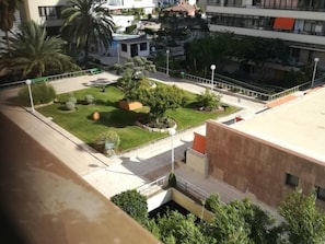 Un patio con césped, árboles y un edificio de techo plano.