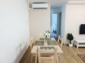 A dining area with a table, chairs, and a potted plant. - Renovated 1-Bedroom Apartment 130 m from the Beach, Bajondillo (Torremolinos)