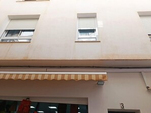 Fachada de edifício com telhado plano, toldo aparente e placa com o número 3.