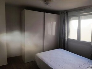 A room with a bed, a wardrobe, and a window. - Renovated 1-Bedroom Apartment 130 m from the Beach, Bajondillo (Torremolinos)