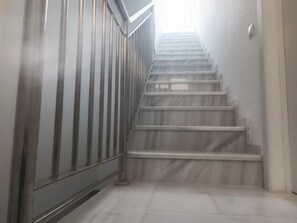 Eine Treppe mit Metallgeländern und Fliesenboden.