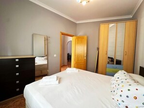 A bedroom with a bed, a dresser, a mirror, and a wardrobe. - 2-Bedroom Apartment 100 m from Bajondillo Beach and the Town Centre (Torremolinos)