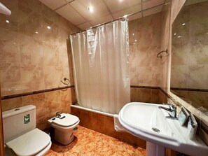 A bathroom with a toilet, sink, and shower curtain. - 2-Bedroom Apartment 100 m from Bajondillo Beach and the Town Centre (Torremolinos)
