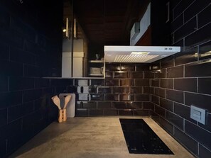 A modern kitchen with dark tiles, a built-in oven, and a black induction cooktop. - 10th-Floor Studio with Terrace and Views in Central Torremolinos (Torremolinos)