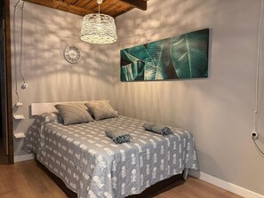 A bedroom with a bed, a wall clock, a hanging light fixture, and a large leaf-patterned painting. - 10th-Floor Studio with Terrace and Views in Central Torremolinos (Torremolinos)