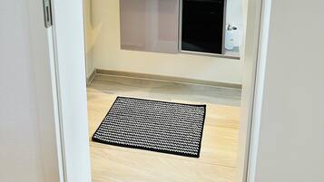 A bathroom with a white sink, mirror, and a black towel hanging on the wall.