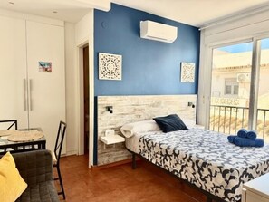 Een slaapkamer met een bed, een stoel, een tafel en een kledingkast.
