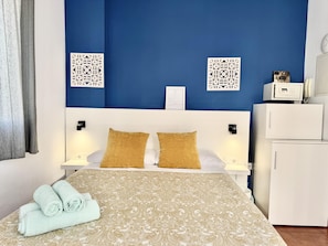 A hotel room with a bed, two pillows, a bedside table, a lamp, a wall-mounted phone, and a small white cabinet. - Sea-View Studio by La Carihuela Beach, Torremolinos (Torremolinos)